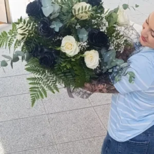 "Detalle de ramo de rosas negras y blancas con eucalipto y paniculata, estilo elegante y moderno"
